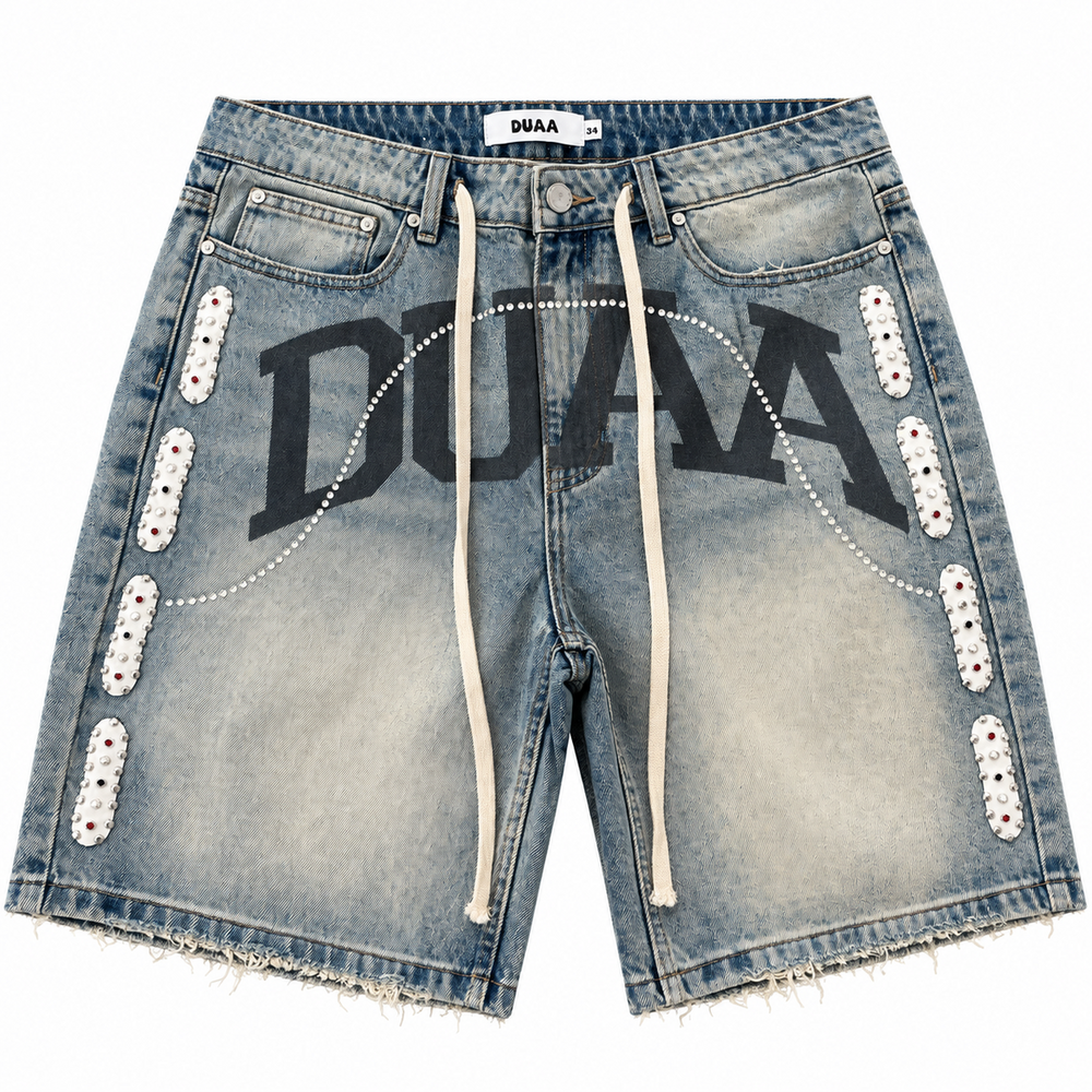 Duaa blue wash denim jorts featuring a large black logo, white studded side panels, and a raw frayed hem.