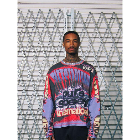 Model wearing a purple, red, and black long-sleeve racing jersey with bold Pure Speed International graphic.