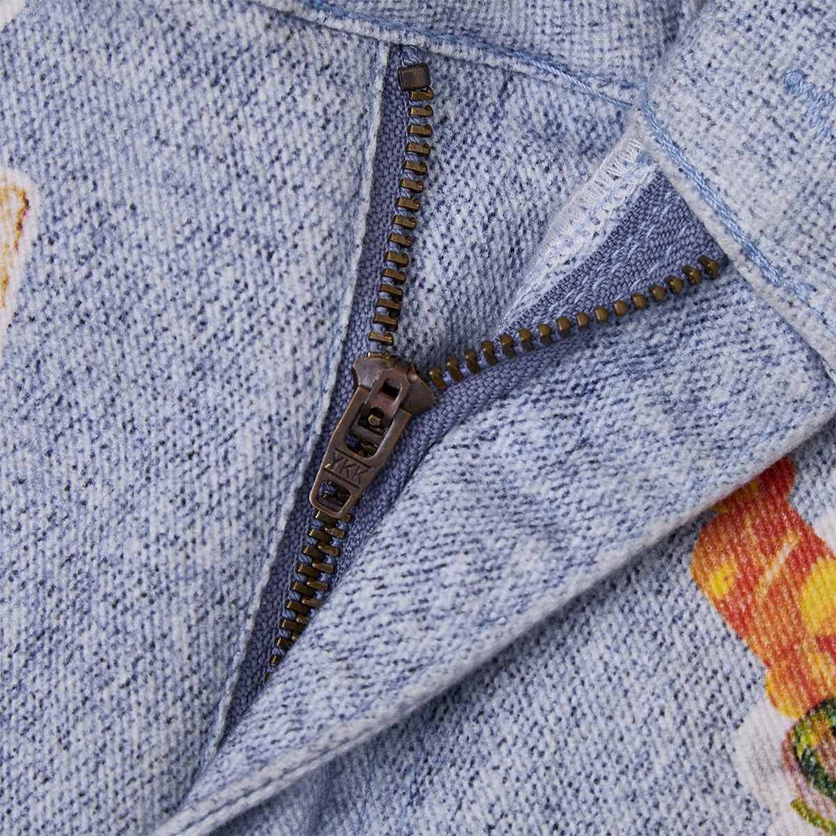 Close-up of a textured fabric with a zipper and printed design.