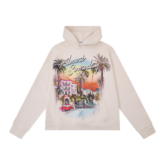 Beige hoodie with a colorful graphic of a cityscape and palm trees on a white background