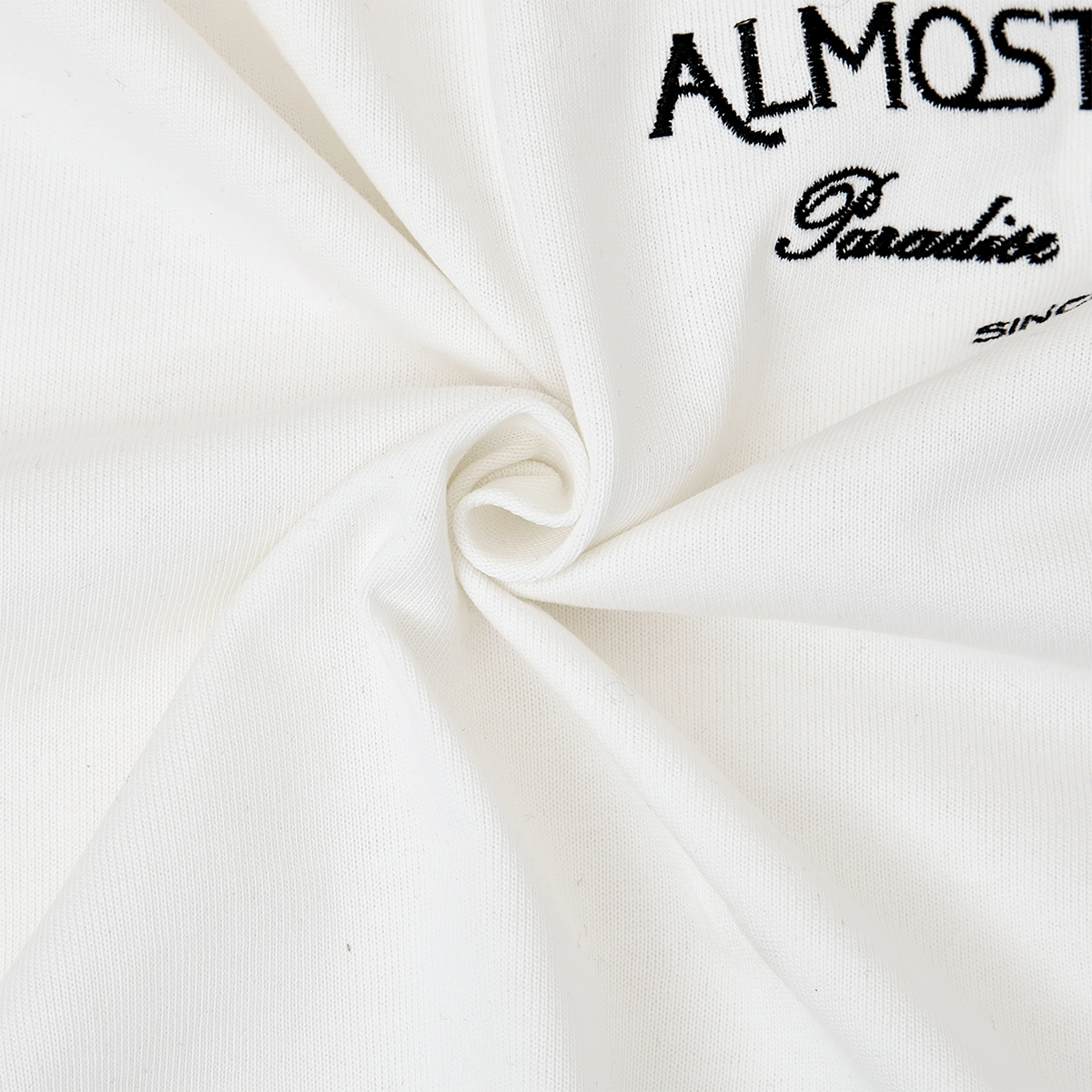 White fabric with black text 'ALMOST Paradise SINCE' on a white background