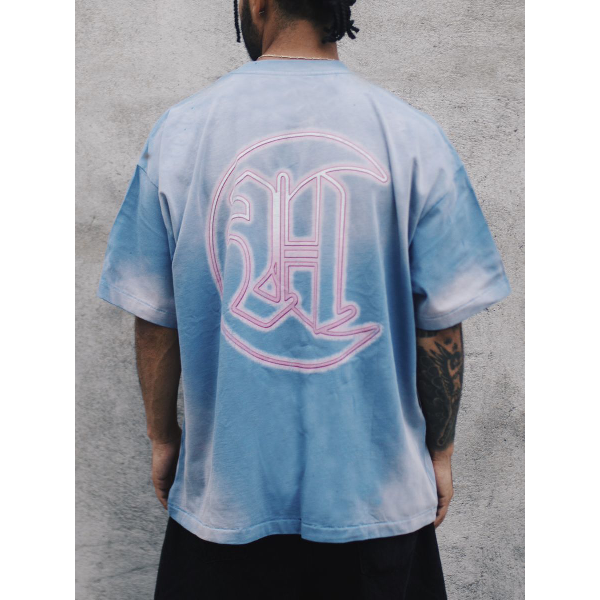 Howlers Club Last Bite Wolf graphic t-shirt back view, featuring pink neon “HC” logo on faded blue vintage wash