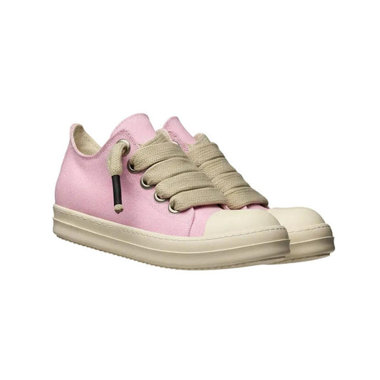 Pink sneakers with beige laces on a decorative column against a gray background