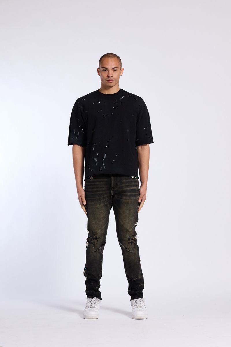 Model showcasing Crysp Denim | Floral Rhinestone Skinny Jeans with a black t-shirt and white sneakers.