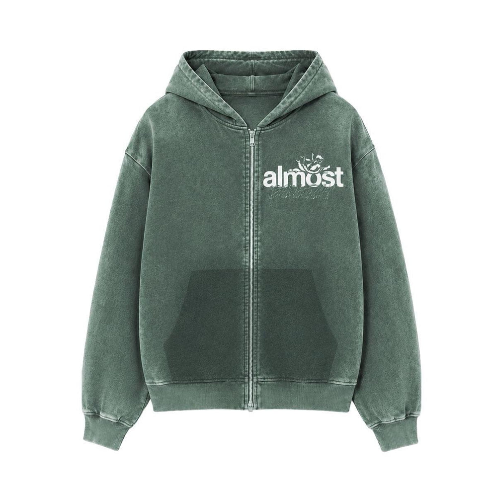 Almost Someday green zip-up hoodie with white graphic logo, front pockets, and ribbed hem in a streetwear style.