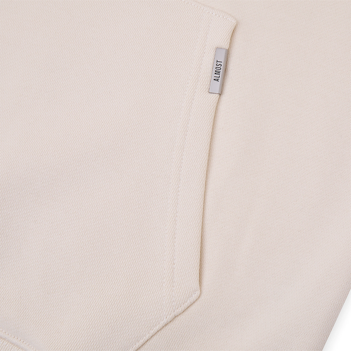 Close-up of a beige fabric with a brand label on a light background