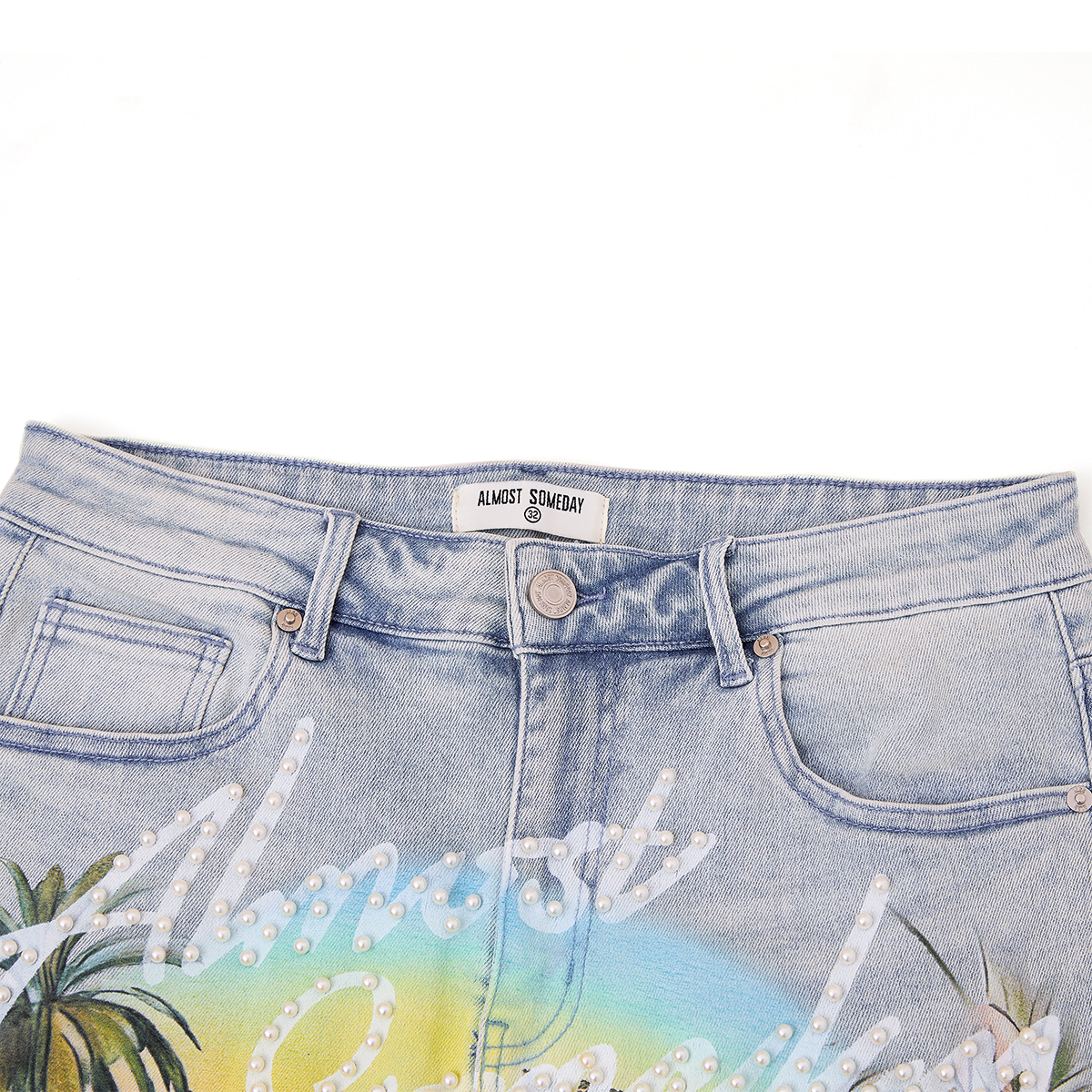 close up on waist of blue denim shorts with pearls and immersive print