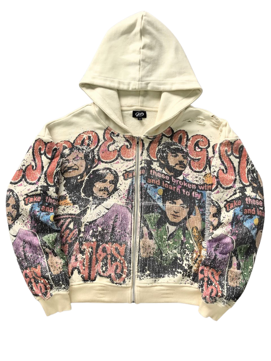Cream-colored zip-up hoodie featuring a distressed, multi-colored Beatles graphic print and a vintage streetwear aesthetic.