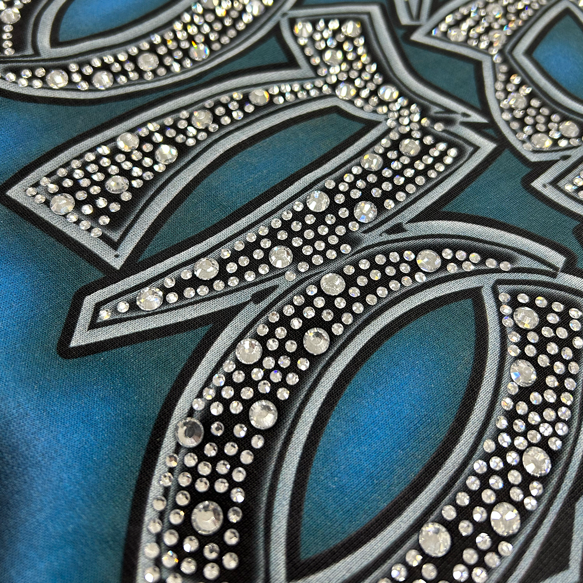 Crystal rhinestone detail and texture of vintage fade on black cotton