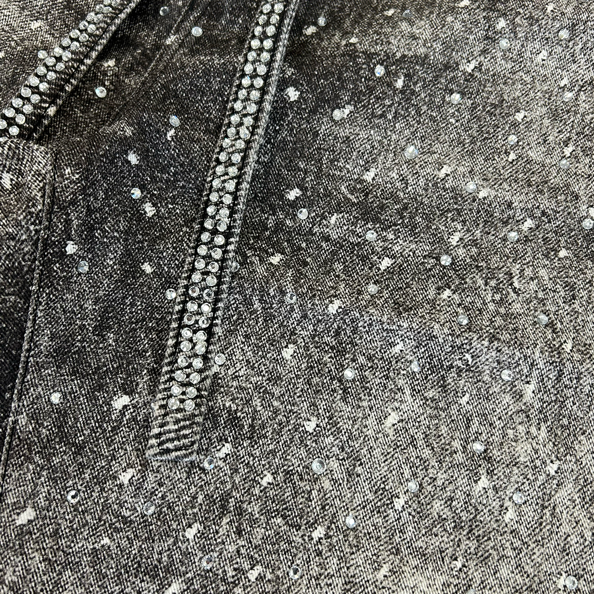 Close-up of black printed denim shorts showcasing shimmering rhinestone accents and detailed printed wash – Undeveloped